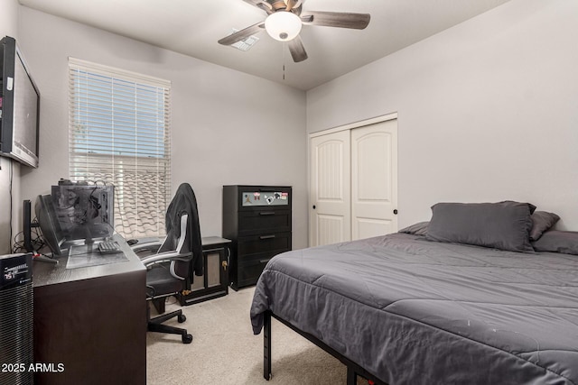 bedroom featuring a ceiling fan, a closet, and light colored carpet