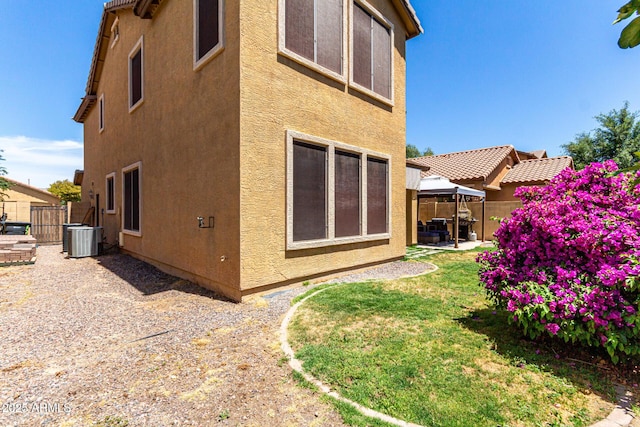 rear view of property featuring a gazebo, a patio area, stucco siding, and fence
