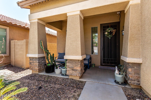 view of exterior entry with stucco siding and stone siding