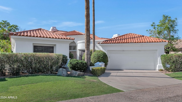 mediterranean / spanish home featuring a front lawn and a garage