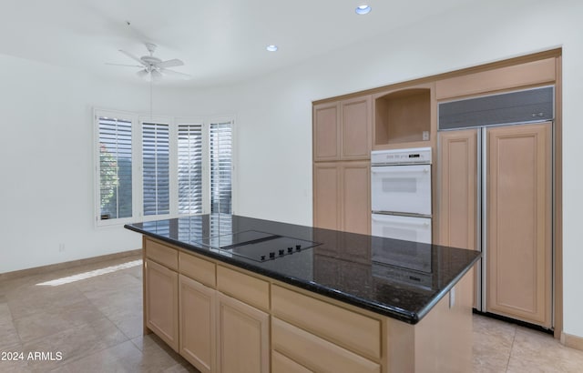 kitchen with ceiling fan, white double oven, paneled refrigerator, black electric stovetop, and a kitchen island