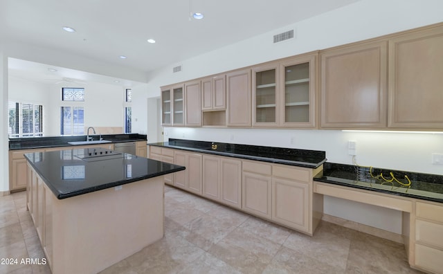 kitchen featuring kitchen peninsula, light brown cabinetry, white dishwasher, sink, and a kitchen island