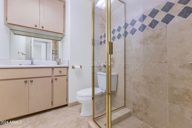 bathroom with tile patterned floors, a shower with door, vanity, and toilet