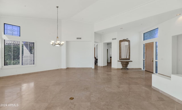 unfurnished room featuring a chandelier and high vaulted ceiling