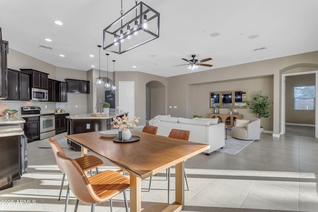 tiled dining room featuring ceiling fan and sink