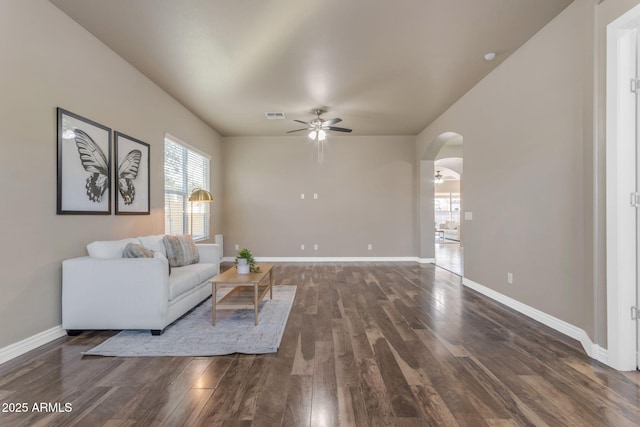 unfurnished living room featuring ceiling fan and dark wood-type flooring