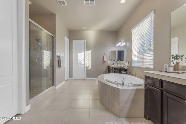 bathroom with tile patterned floors, vanity, and shower with separate bathtub