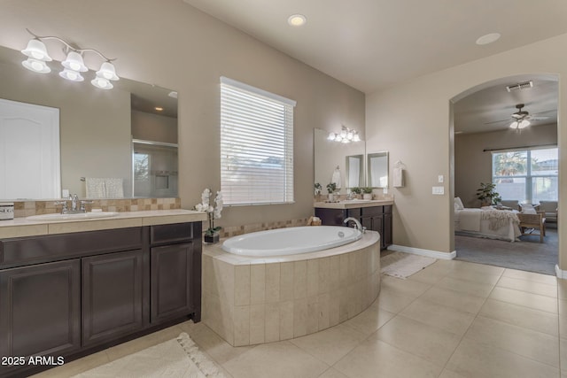 bathroom featuring tile patterned flooring, ceiling fan, plenty of natural light, and tiled tub