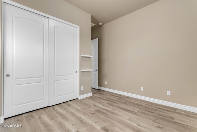 unfurnished bedroom featuring light hardwood / wood-style flooring and a closet