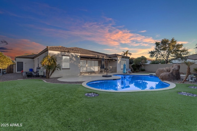 pool at dusk featuring a yard and a patio area