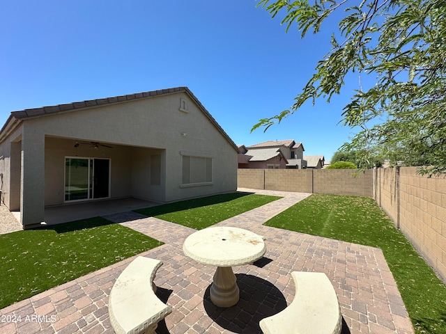 rear view of house featuring a patio, a yard, and ceiling fan