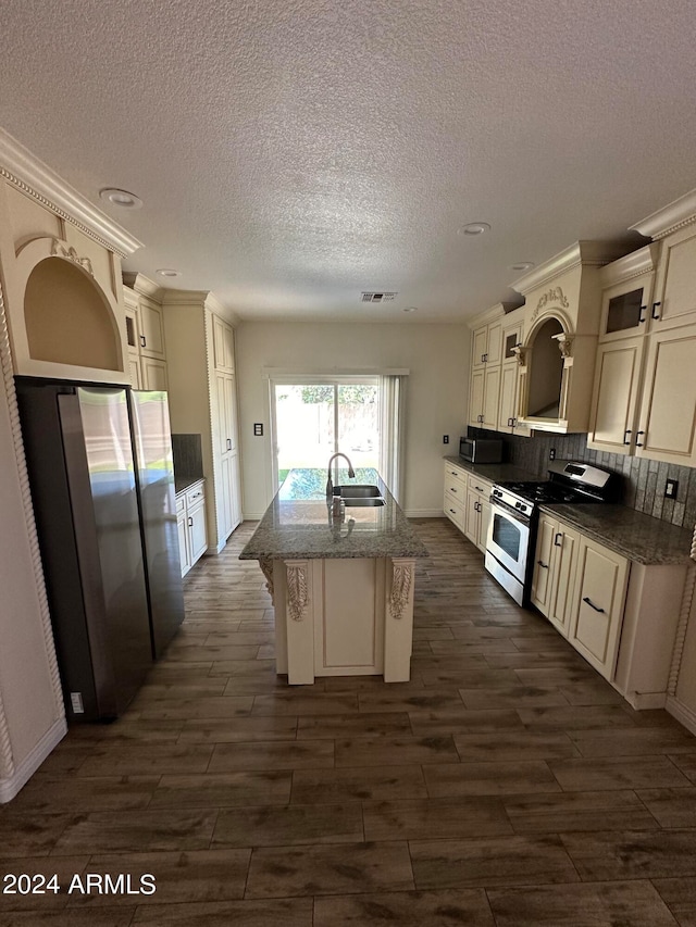 kitchen featuring backsplash, gas range, stone countertops, sink, and a breakfast bar area