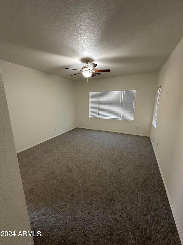 empty room featuring carpet, a textured ceiling, and ceiling fan