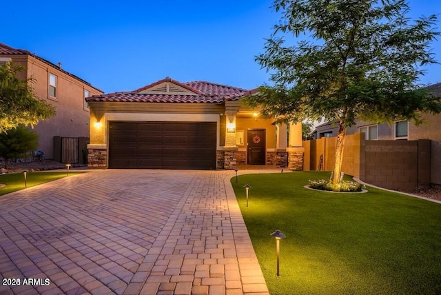 view of front of property featuring a garage, stone siding, fence, decorative driveway, and stucco siding