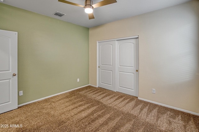 unfurnished bedroom featuring a ceiling fan, visible vents, baseboards, a closet, and carpet