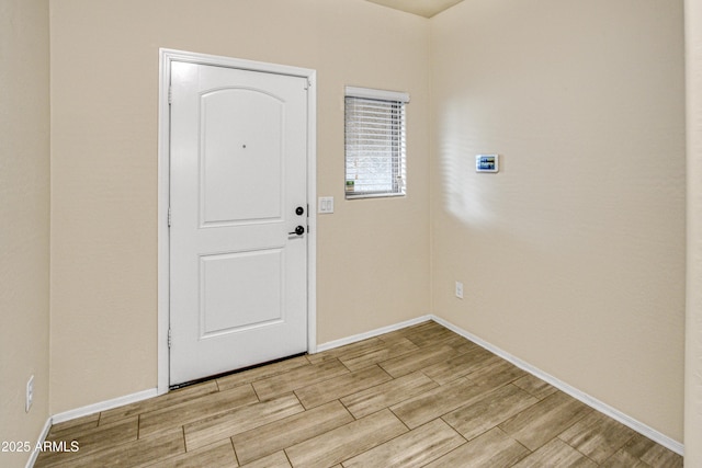 foyer featuring baseboards and wood tiled floor