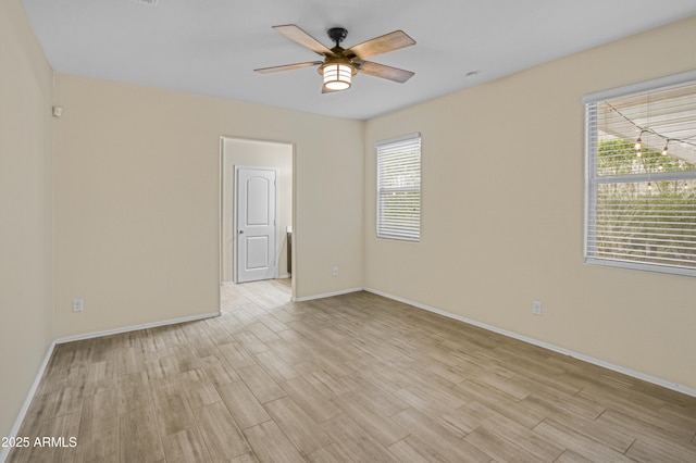 unfurnished room featuring a ceiling fan, light wood-type flooring, and baseboards