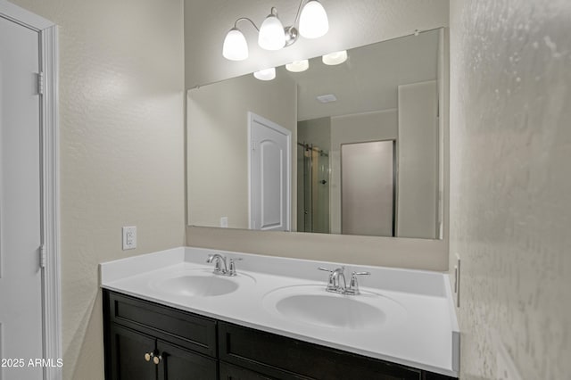 bathroom featuring a textured wall, double vanity, a sink, and a shower with curtain