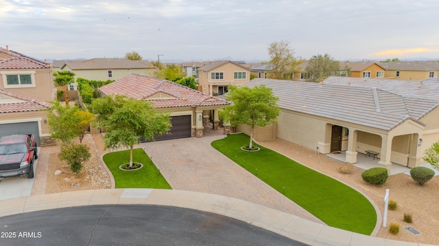 view of front of property featuring decorative driveway, a tile roof, stucco siding, an attached garage, and a residential view