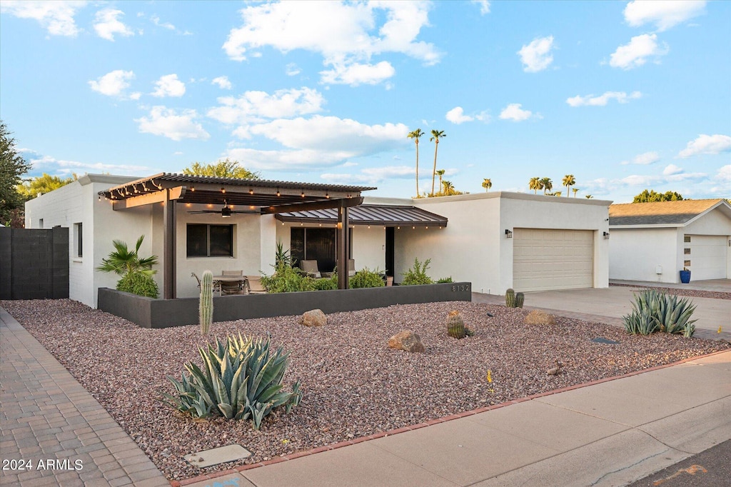 view of front facade featuring a garage and a pergola