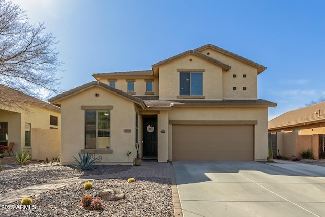 view of front of house with an attached garage, fence, driveway, a tiled roof, and stucco siding