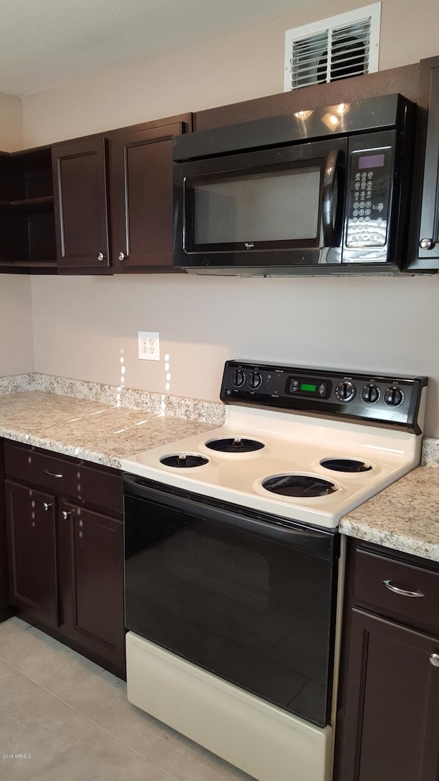 725 E Hidalgo Ave, Phoenix, AZ 85040 - kitchen with white electric stove, black microwave, dark brown cabinets, open shelves, and light countertops