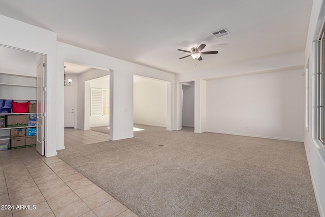 11122 E Tripoli Ave, Mesa, AZ 85212 - empty room with a ceiling fan, light tile patterned floors, light carpet, and a chandelier