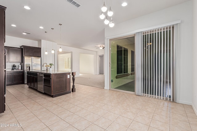 11122 E Tripoli Ave, Mesa, AZ 85212 - kitchen featuring dark brown cabinetry, pendant lighting, light tile patterned floors, open floor plan, and stainless steel dishwasher
