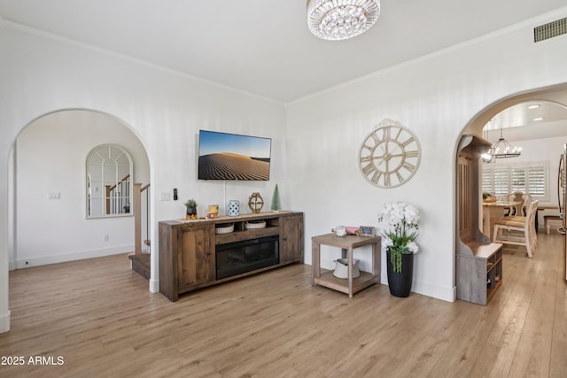 4735 E Harmony Cir, Mesa, AZ 85206 - living area featuring a chandelier, arched walkways, wood finished floors, and crown molding