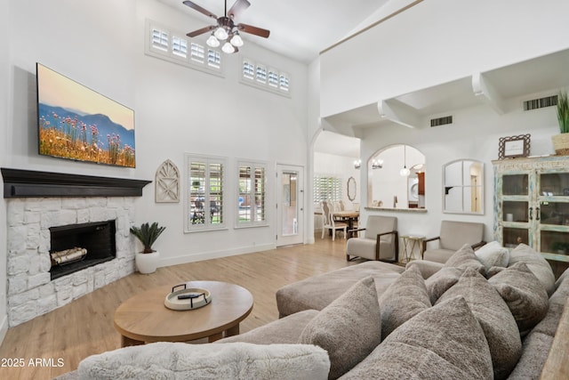 4735 E Harmony Cir, Mesa, AZ 85206 - living area with a ceiling fan, a high ceiling, wood finished floors, and a fireplace