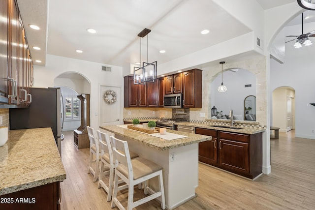 4735 E Harmony Cir, Mesa, AZ 85206 - kitchen featuring arched walkways, stainless steel appliances, tasteful backsplash, and recessed lighting