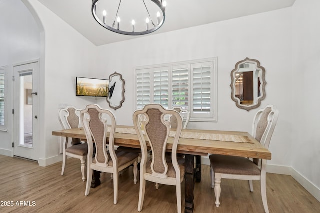 4735 E Harmony Cir, Mesa, AZ 85206 - dining area featuring a chandelier, arched walkways, light wood finished floors, and lofted ceiling