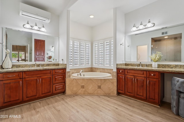 4735 E Harmony Cir, Mesa, AZ 85206 - bathroom with a wall mounted air conditioner, wood finished floors, two vanities, a bath, and a stall shower