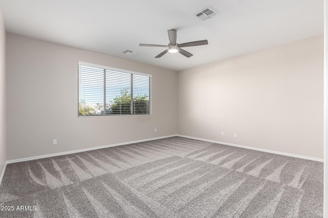 carpeted empty room featuring baseboards, visible vents, and a ceiling fan