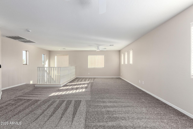 spare room featuring carpet flooring, visible vents, and baseboards