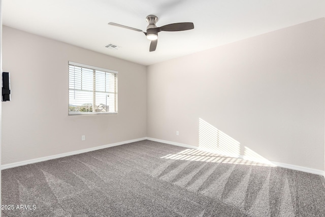 spare room featuring carpet, visible vents, and baseboards