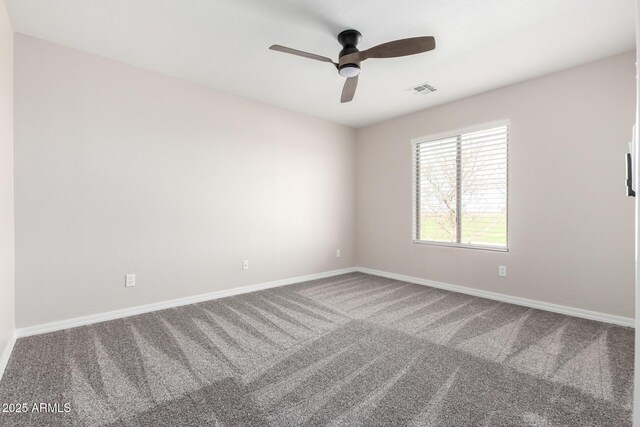 carpeted empty room with visible vents, baseboards, and a ceiling fan