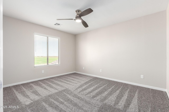 carpeted spare room with visible vents, ceiling fan, and baseboards