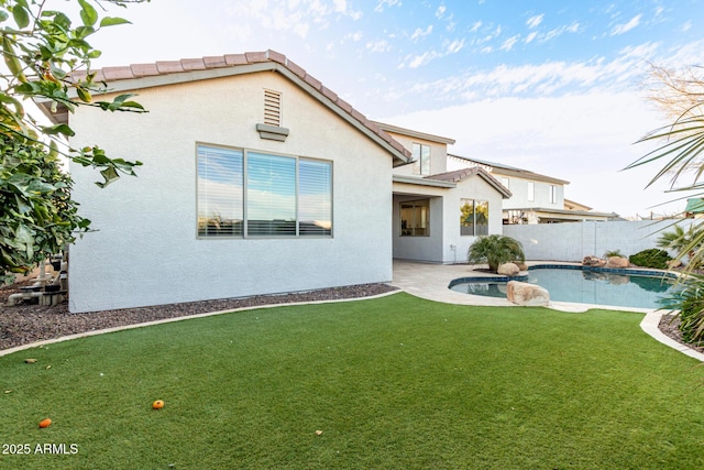 rear view of property with a fenced in pool, a patio, a fenced backyard, a tiled roof, and stucco siding