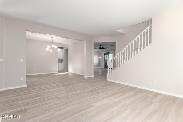 unfurnished living room featuring light wood-style flooring, stairway, baseboards, and ceiling fan with notable chandelier