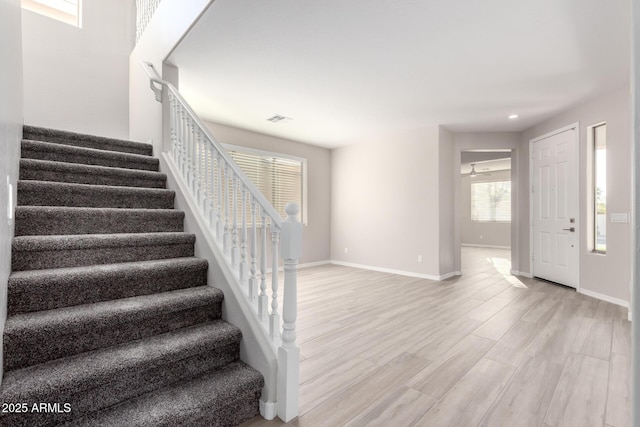 staircase with recessed lighting, wood finished floors, visible vents, and baseboards