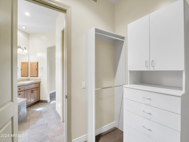 walk in closet featuring light tile patterned flooring and sink