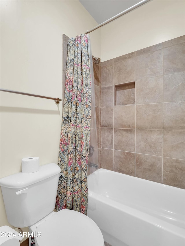 bathroom with shower / bathtub combination with curtain and toilet