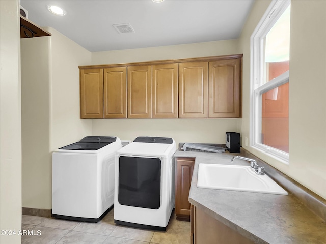 laundry area with cabinets, sink, washing machine and dryer, and light tile patterned floors