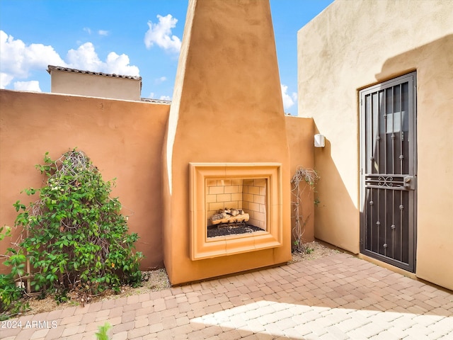 property entrance featuring exterior fireplace and a patio area