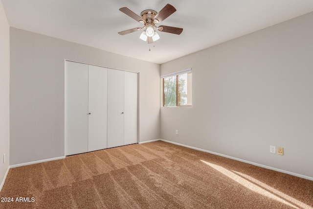 unfurnished bedroom with ceiling fan, carpet floors, and a closet