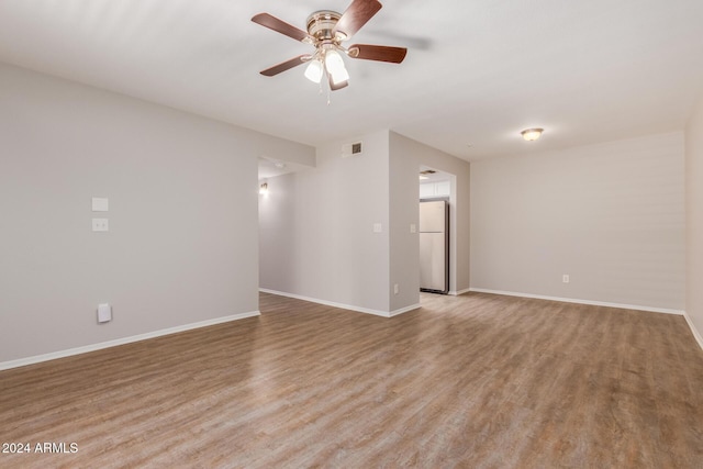 spare room with ceiling fan and light wood-type flooring