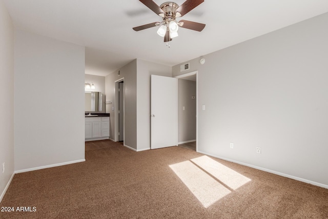 unfurnished bedroom with carpet floors, ensuite bathroom, and ceiling fan