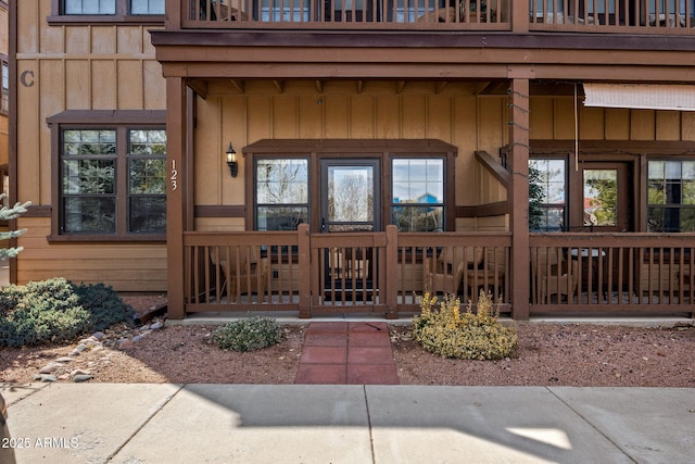 entrance to property featuring a balcony and board and batten siding