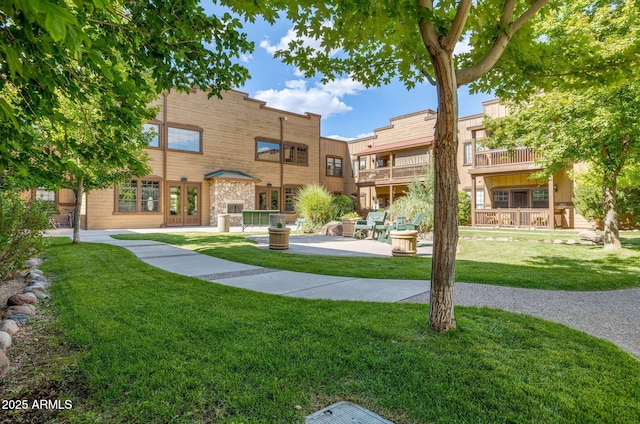 view of home's community featuring a patio and a lawn